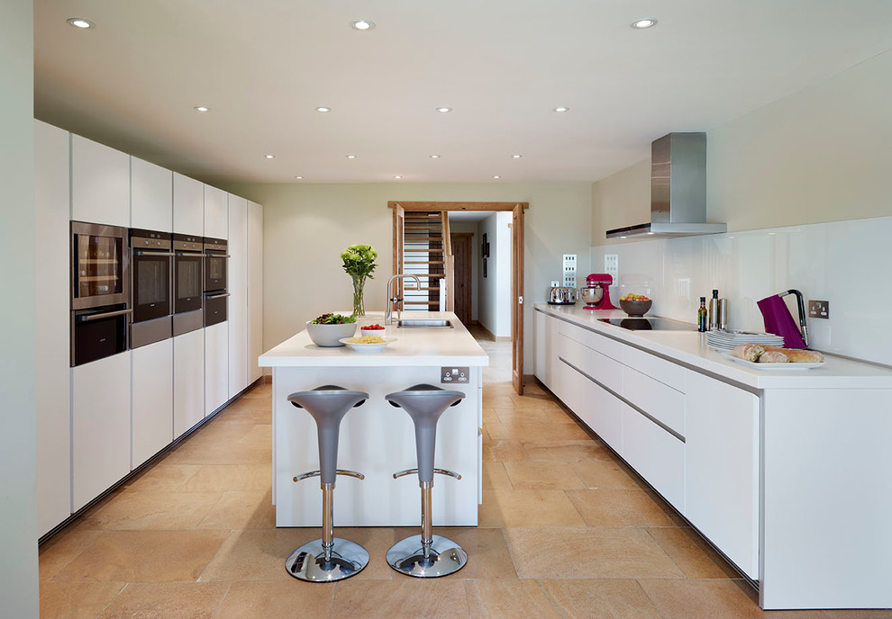Photo of a contemporary galley eat-in kitchen in Wiltshire with white cabinets, laminate benchtops, white splashback, glass sheet splashback and stainless steel appliances.