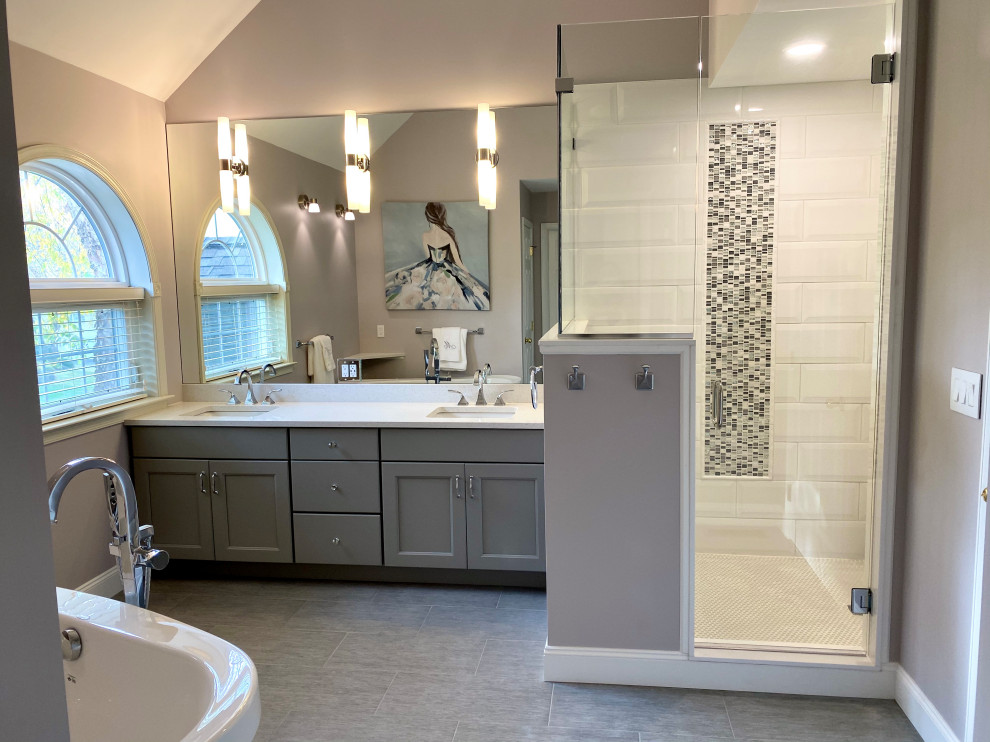 Design ideas for a large transitional master bathroom in Philadelphia with flat-panel cabinets, grey cabinets, a freestanding tub, a two-piece toilet, grey walls, ceramic floors, an undermount sink, engineered quartz benchtops, grey floor, white benchtops, a shower seat, a double vanity and a built-in vanity.