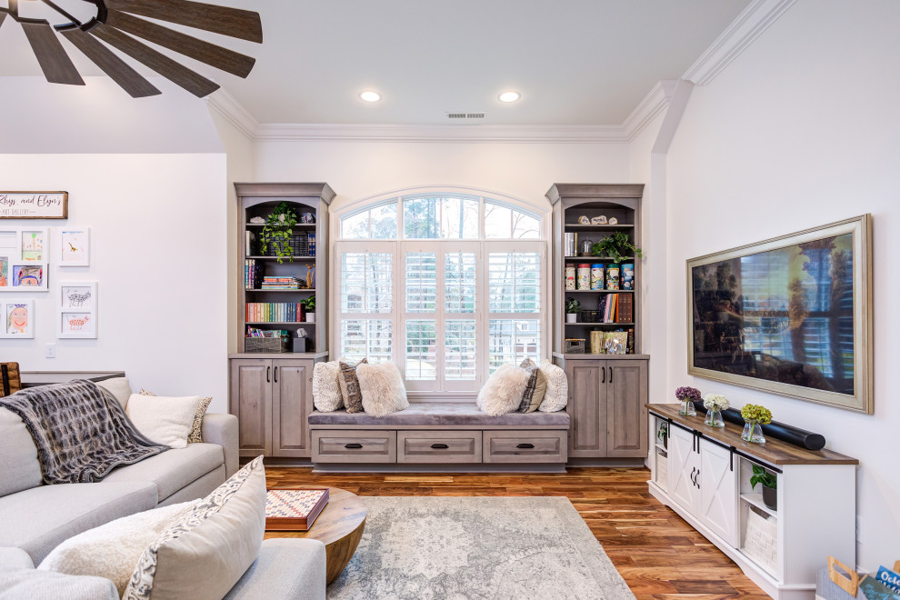 This is an example of a large transitional gender-neutral kids' playroom in Raleigh with white walls, medium hardwood floors and brown floor.