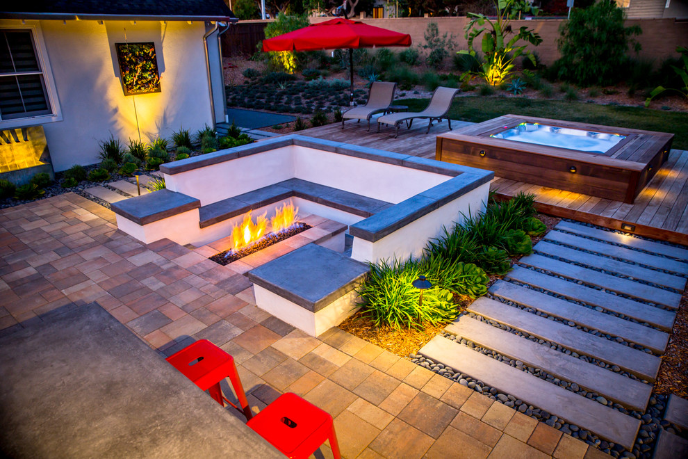 Photo of a large contemporary backyard patio in Tampa with a fire feature, concrete pavers and no cover.