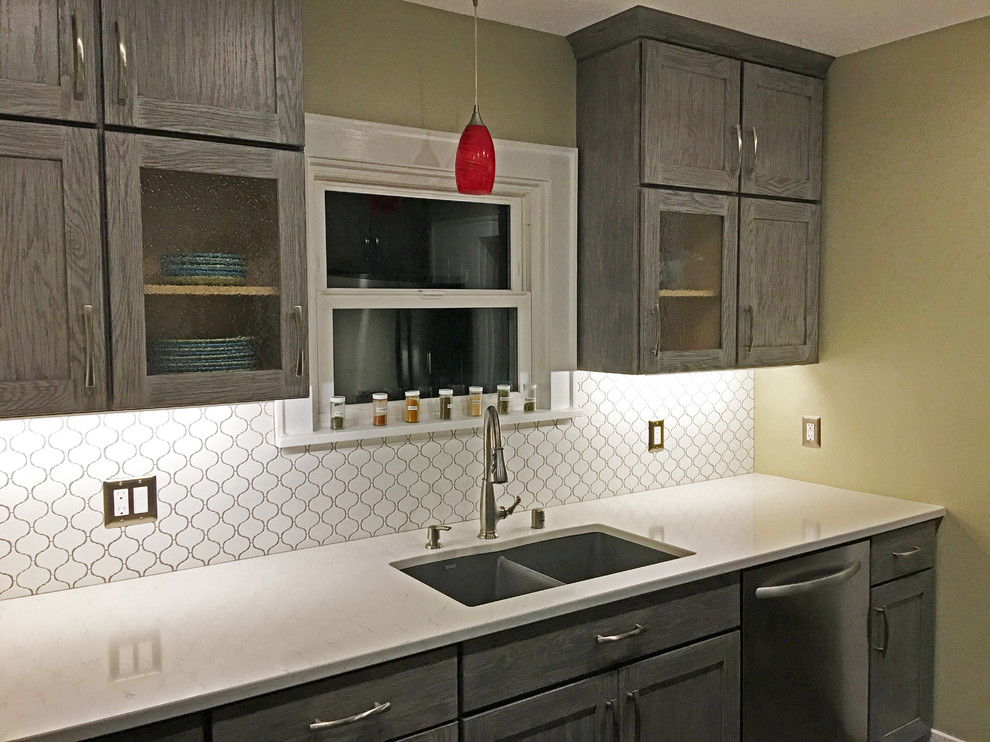Small transitional galley enclosed kitchen photo in Seattle with an undermount sink, shaker cabinets, gray cabinets, quartzite countertops, white backsplash, ceramic backsplash, stainless steel appliances and no island