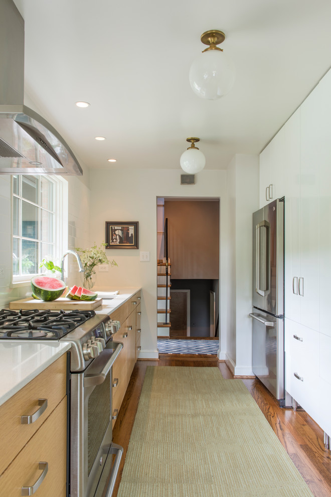 Inspiration for a mid-sized transitional galley medium tone wood floor enclosed kitchen remodel in DC Metro with an undermount sink, flat-panel cabinets, light wood cabinets, quartz countertops, stainless steel appliances and no island