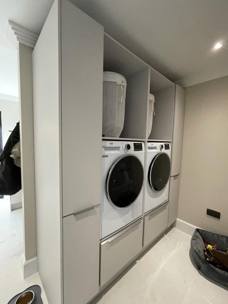 This is an example of a contemporary laundry room in Other with an integrated sink, flat-panel cabinets, grey cabinets, quartzite benchtops, white splashback, stone slab splashback, beige walls, porcelain floors, a side-by-side washer and dryer, white floor and white benchtop.