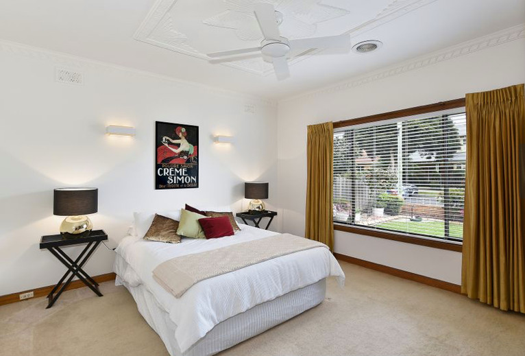 This is an example of a large midcentury master bedroom in Melbourne with white walls, carpet and beige floor.