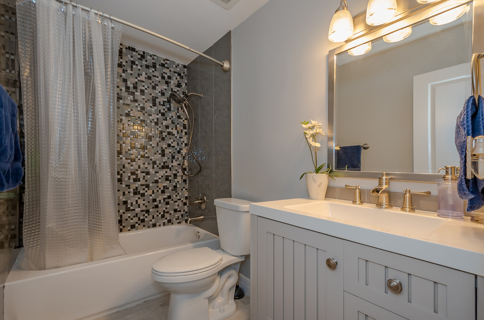 Design ideas for a mid-sized transitional kids bathroom in Miami with shaker cabinets, grey cabinets, an alcove tub, an alcove shower, beige tile, subway tile, blue walls, ceramic floors, an undermount sink, soapstone benchtops, grey floor, a shower curtain and beige benchtops.