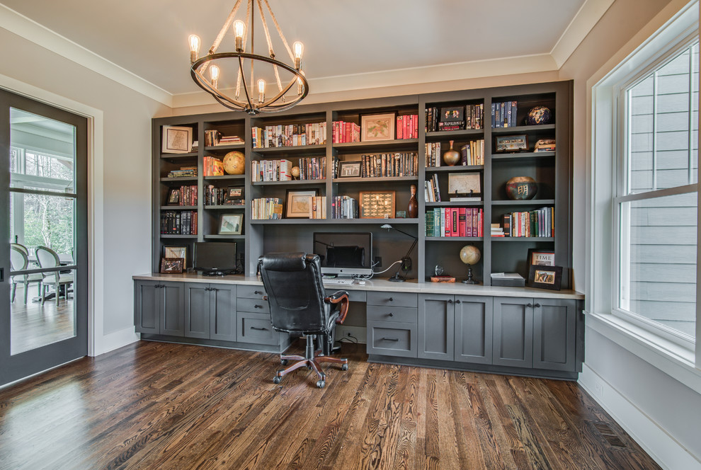 Photo of a transitional study room in Charlotte with grey walls, a built-in desk and dark hardwood floors.