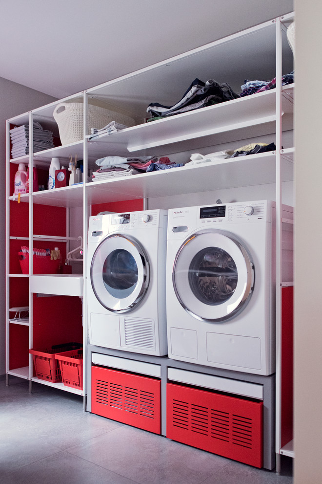 Photo of a mid-sized contemporary single-wall dedicated laundry room in Frankfurt with open cabinets, white cabinets, grey walls, terra-cotta floors and grey floor.