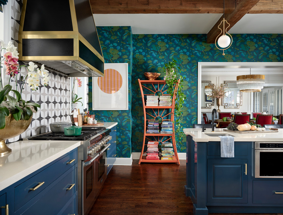 Stilmix Küche mit Unterbauwaschbecken, blauen Schränken, Quarzwerkstein-Arbeitsplatte, Küchengeräten aus Edelstahl, dunklem Holzboden, Kücheninsel, weißer Arbeitsplatte, freigelegten Dachbalken und Tapete in Denver