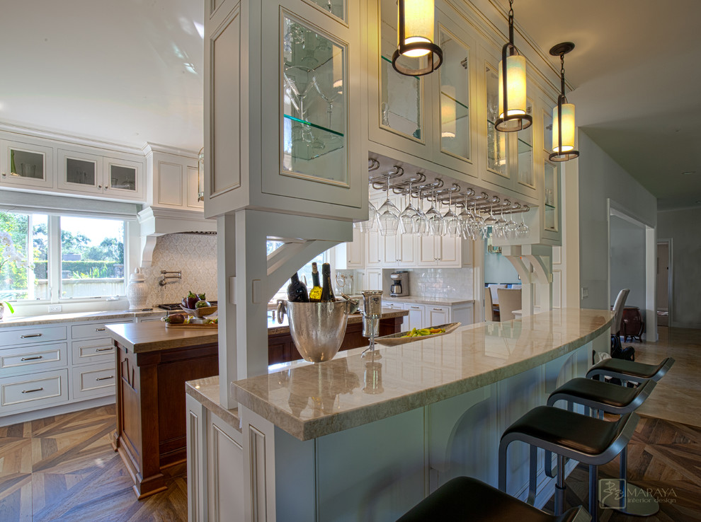 This is an example of a large country u-shaped seated home bar in Los Angeles with an undermount sink, recessed-panel cabinets, white cabinets, quartzite benchtops, white splashback, mosaic tile splashback and porcelain floors.