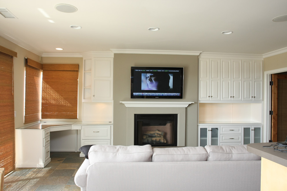 Inspiration for a mid-sized beach style open concept family room in Orange County with grey walls, slate floors, a standard fireplace, a plaster fireplace surround and a wall-mounted tv.