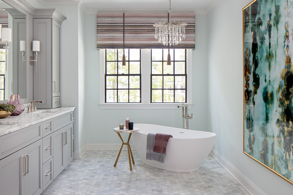 Photo of a large traditional master bathroom in Richmond with recessed-panel cabinets, an alcove shower, a two-piece toilet, an undermount sink, marble benchtops, a hinged shower door, a double vanity, a built-in vanity, grey cabinets, a freestanding tub, marble, blue walls and marble floors.