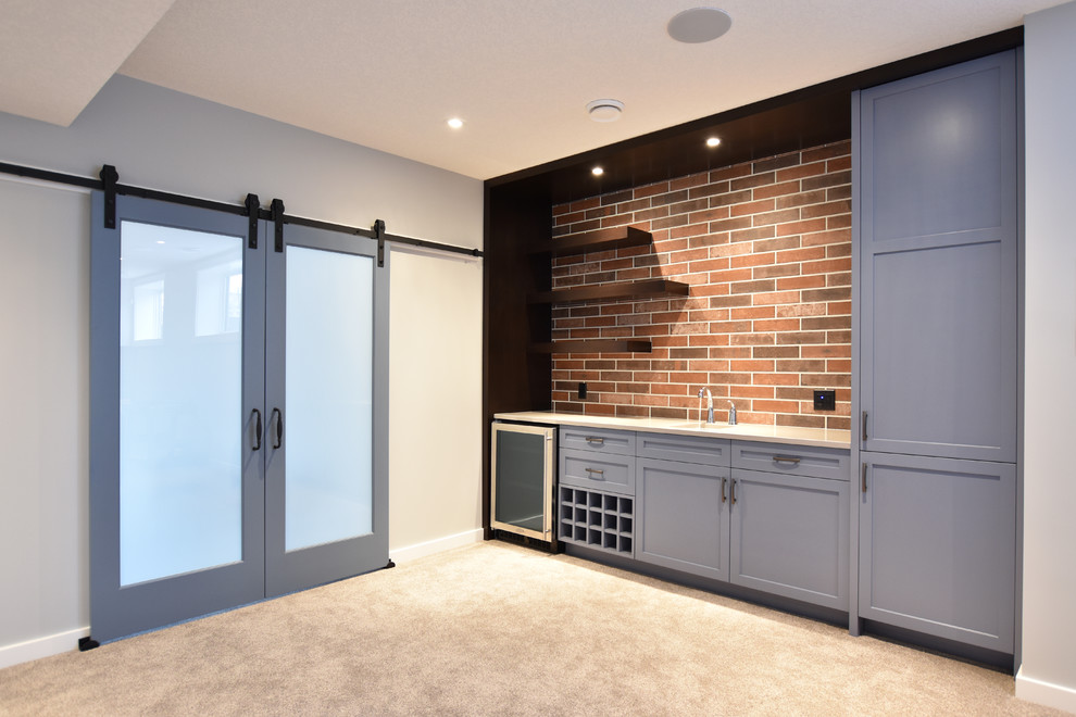 This is an example of a mid-sized contemporary single-wall wet bar in Calgary with an undermount sink, shaker cabinets, blue cabinets, quartz benchtops, brick splashback, carpet and beige floor.