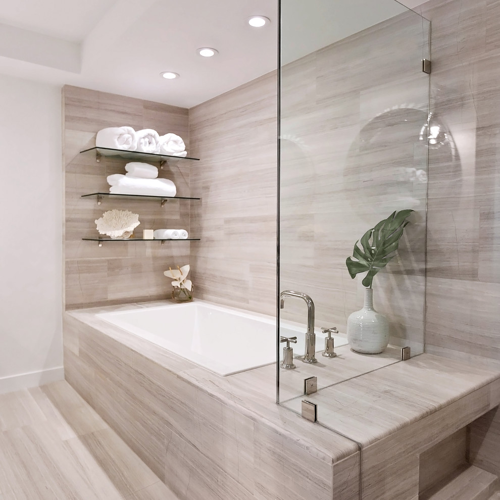Contemporary bathroom in Miami with a drop-in tub, beige walls and beige floor.