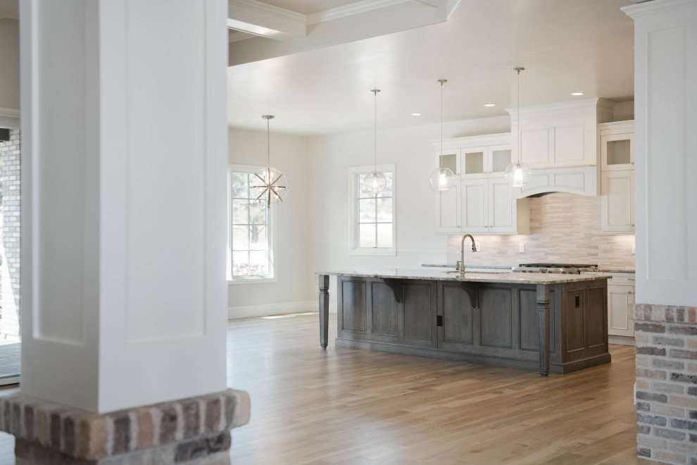 Example of a large transitional l-shaped light wood floor and brown floor eat-in kitchen design in Denver with an undermount sink, flat-panel cabinets, gray cabinets, granite countertops, beige backsplash, stainless steel appliances, an island and gray countertops