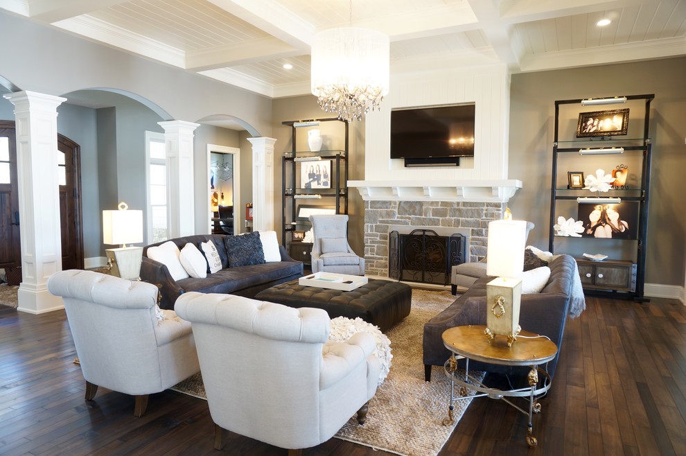 This is an example of a large arts and crafts open concept living room in Cleveland with grey walls, bamboo floors, a standard fireplace, a stone fireplace surround and a wall-mounted tv.