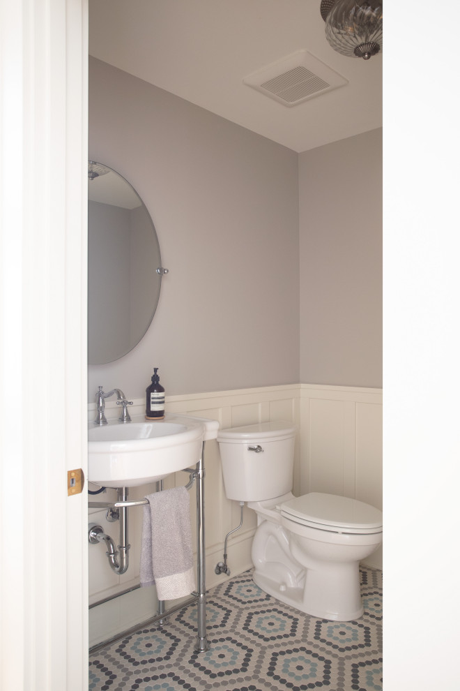 Inspiration for a mid-sized traditional powder room in Minneapolis with a one-piece toilet, purple walls, a wall-mount sink, multi-coloured floor, decorative wall panelling and mosaic tile floors.