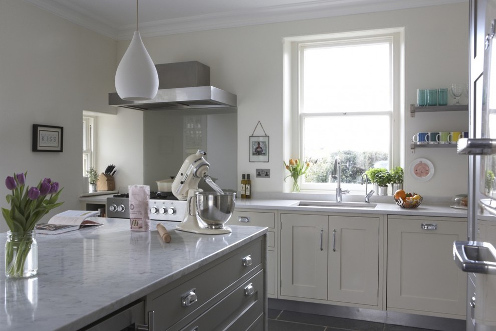 Inspiration for a large country eat-in kitchen in London with an undermount sink, shaker cabinets, marble benchtops, stainless steel appliances, limestone floors and with island.