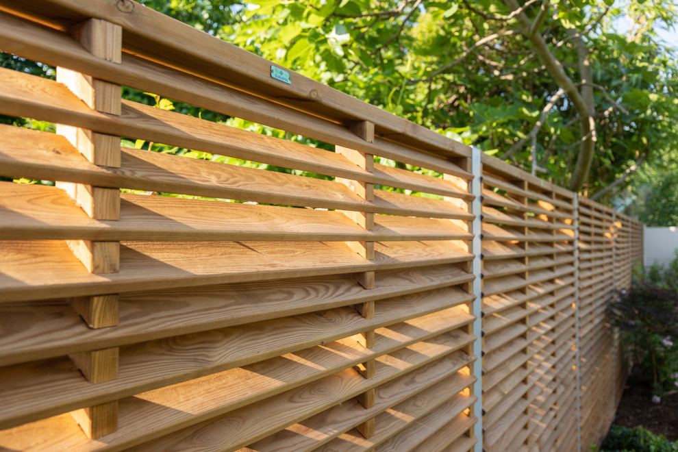 Inspiration pour un jardin arrière traditionnel de taille moyenne et l'été avec une exposition partiellement ombragée et une clôture en bois.