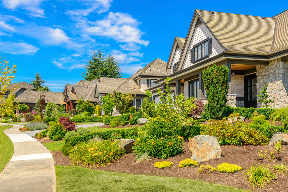 Design ideas for a large transitional full sun front yard mulch formal garden in Calgary.