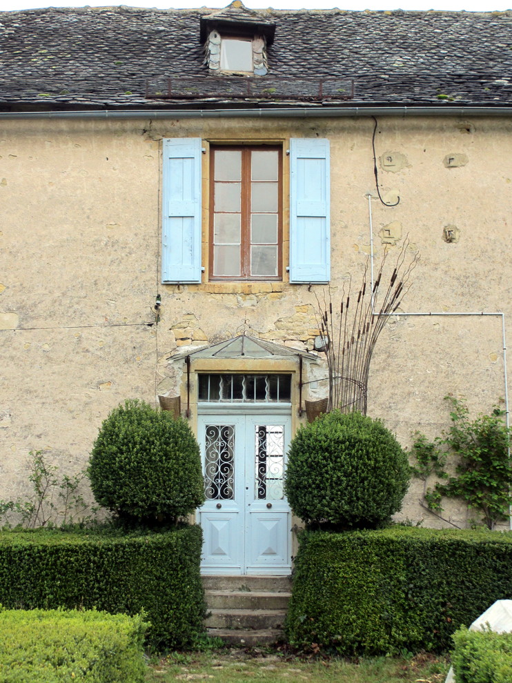 Design ideas for a mid-sized traditional two-storey stucco beige exterior in Toulouse with a gable roof.