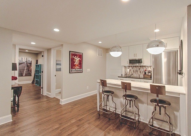 Inspiration for a small transitional galley kitchen remodel in DC Metro with shaker cabinets, white cabinets, glass tile backsplash, stainless steel appliances and an island