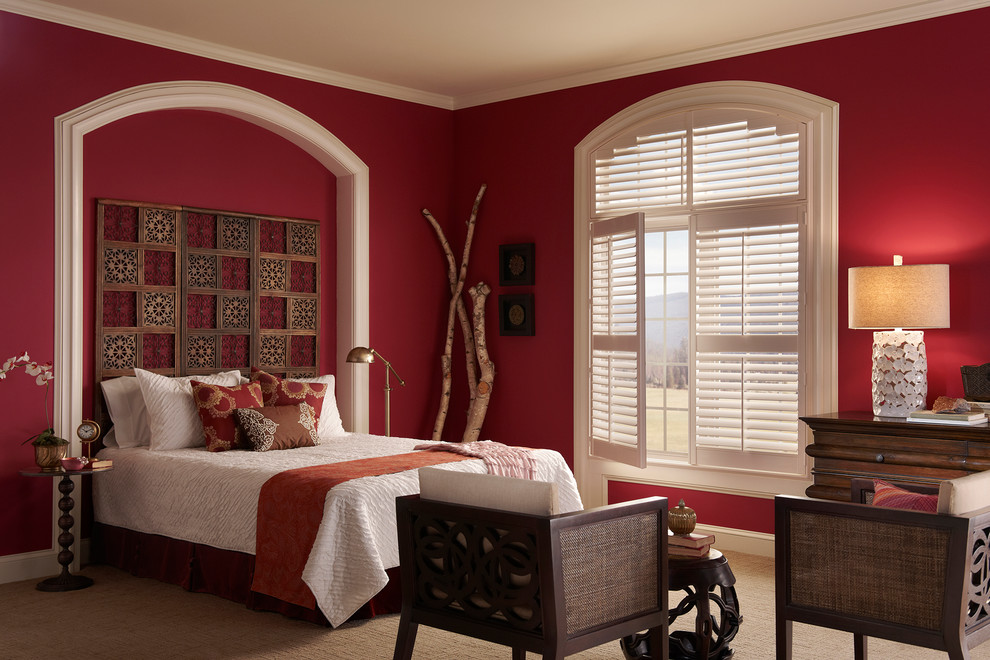 This is an example of a mid-sized traditional master bedroom in Atlanta with red walls and carpet.