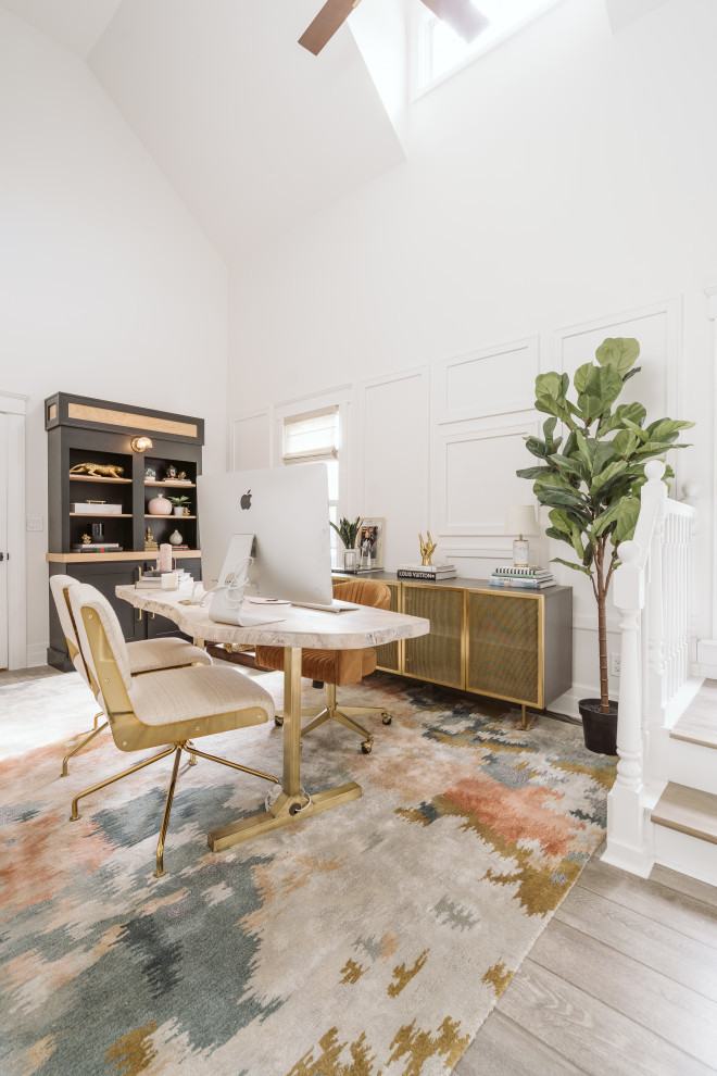 Inspiration for a mid-sized contemporary home office in Detroit with white walls, light hardwood floors, a freestanding desk, grey floor, vaulted and panelled walls.