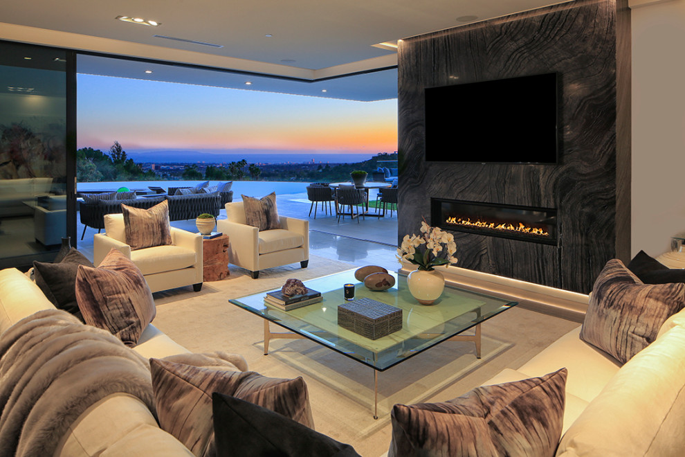 Mid-sized contemporary open concept living room in Los Angeles with white walls, limestone floors, a ribbon fireplace, a stone fireplace surround, a wall-mounted tv and grey floor.