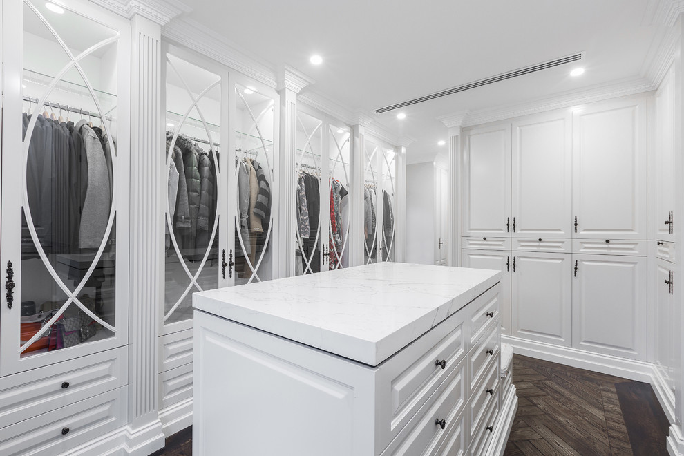 Photo of a large contemporary walk-in wardrobe in Melbourne with glass-front cabinets, white cabinets and dark hardwood floors.