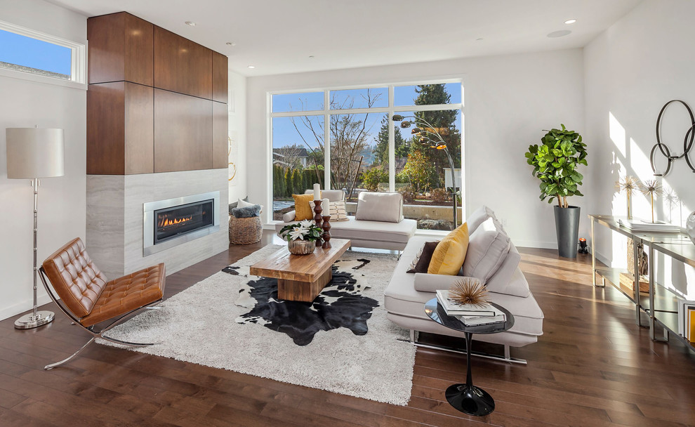 This is an example of a contemporary open concept living room in Seattle with white walls, medium hardwood floors, a ribbon fireplace, a stone fireplace surround and brown floor.