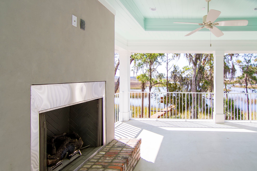 Photo of a mid-sized beach style backyard verandah in Jacksonville with a fire feature, concrete slab and a roof extension.