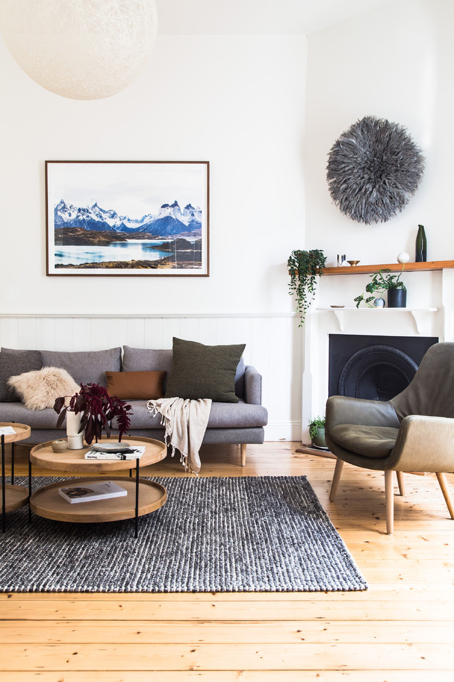 This is an example of a contemporary open concept living room in Melbourne with white walls, light hardwood floors, a standard fireplace, a metal fireplace surround and brown floor.