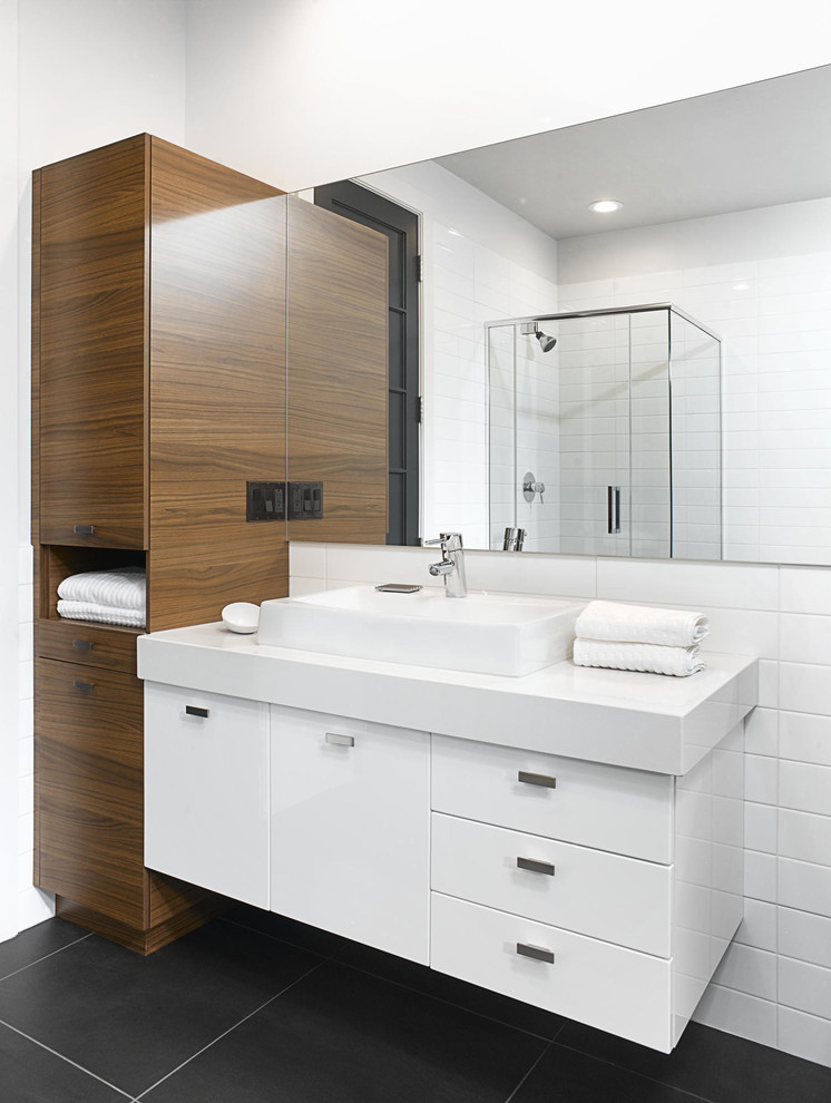This is an example of a contemporary master bathroom in Montreal with flat-panel cabinets, white cabinets, a corner shower, white tile, ceramic tile, white walls, ceramic floors, a vessel sink and quartzite benchtops.