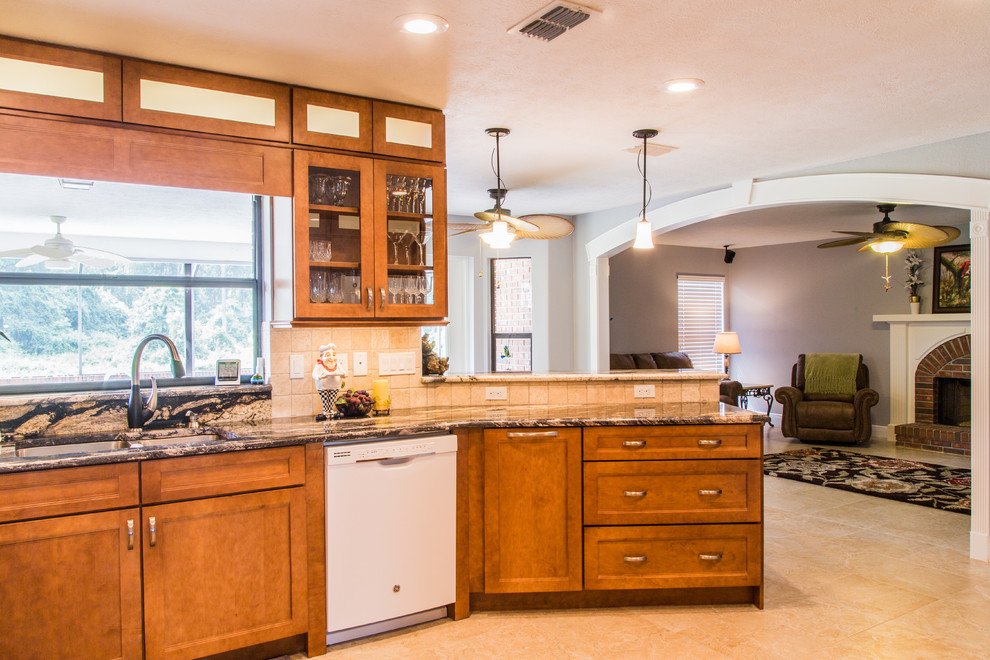 Inspiration for a mid-sized eclectic u-shaped eat-in kitchen in Tampa with shaker cabinets, medium wood cabinets, granite benchtops, beige splashback, ceramic splashback, white appliances, linoleum floors and a peninsula.