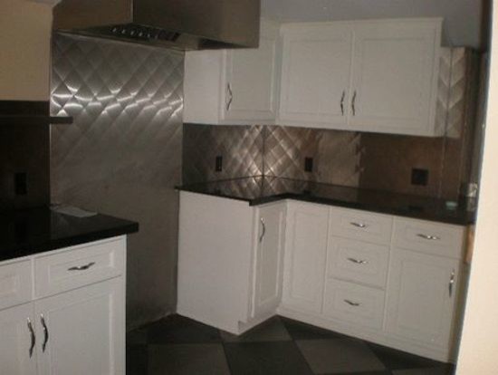 Example of a kitchen design in Phoenix with white cabinets