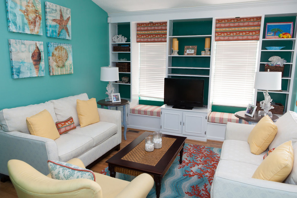 Design ideas for a mid-sized tropical living room in DC Metro with blue walls, a freestanding tv, medium hardwood floors, no fireplace and brown floor.