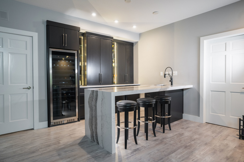 This is an example of a medium sized modern galley wet bar in Other with a submerged sink, flat-panel cabinets, black cabinets, engineered stone countertops, vinyl flooring, grey floors and multicoloured worktops.