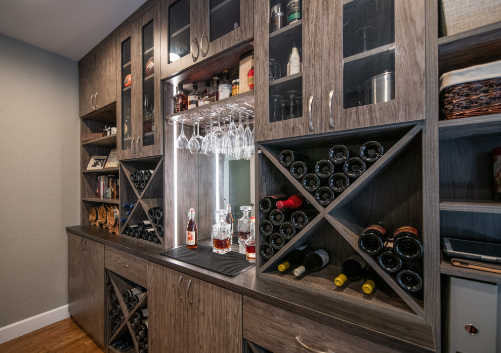 Photo of a mid-sized contemporary l-shaped home bar in Denver with flat-panel cabinets, medium wood cabinets, laminate benchtops and brown benchtop.