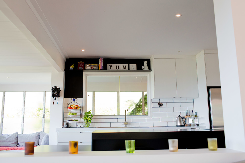 Inspiration for a mid-sized eclectic eat-in kitchen in Sunshine Coast with white splashback, subway tile splashback and with island.