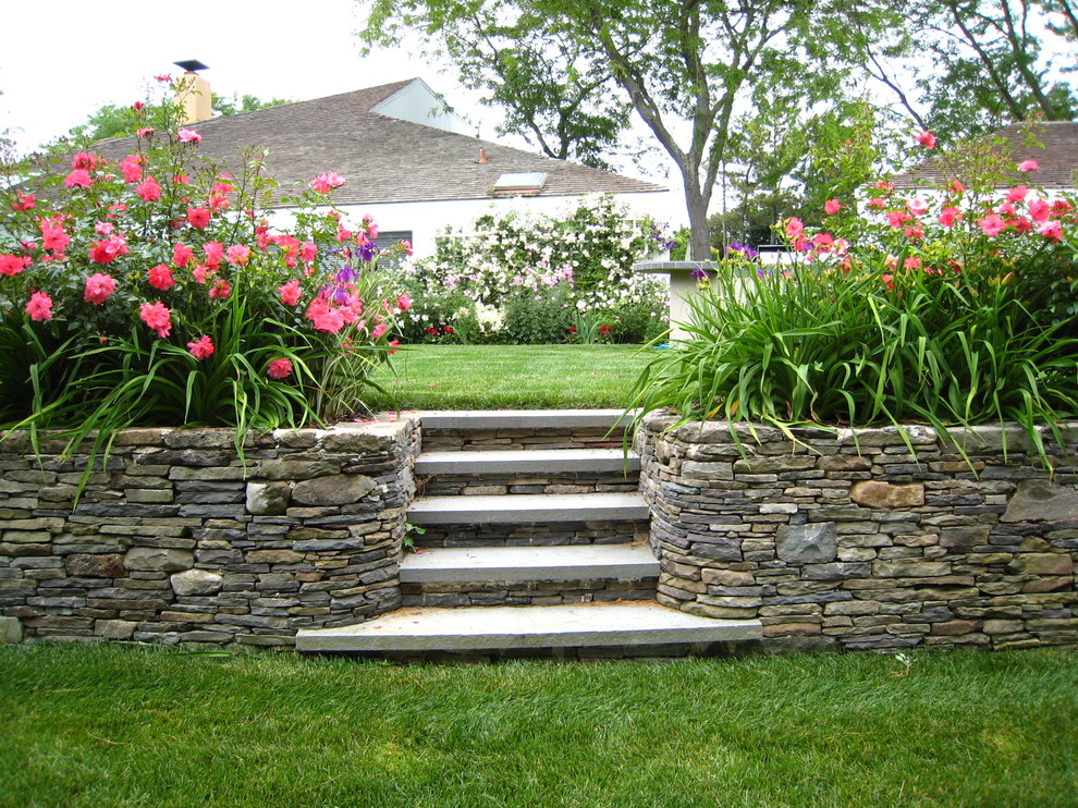 Design ideas for a traditional garden in Other with a retaining wall and natural stone pavers.