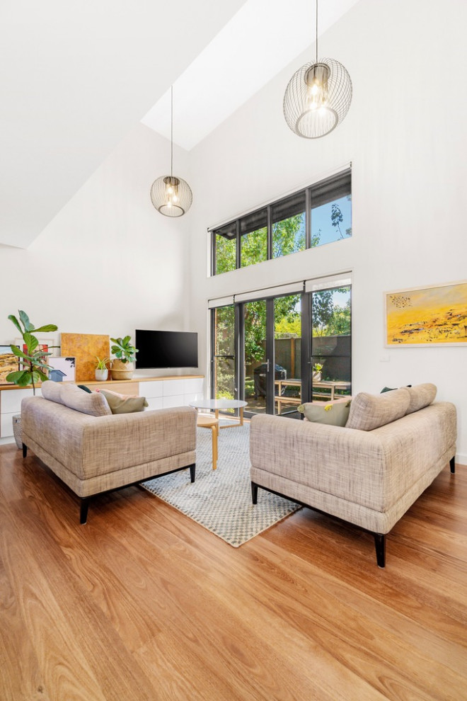 Inspiration for a modern living room in Melbourne with light hardwood floors.