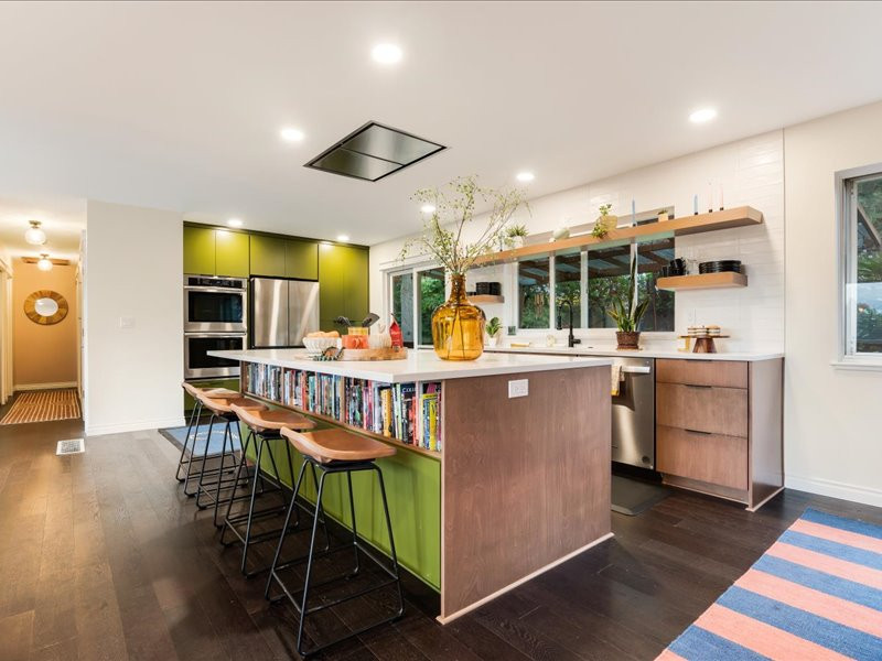 Design ideas for a mid-sized midcentury kitchen in Portland with an undermount sink, flat-panel cabinets, green cabinets, quartz benchtops, white splashback, ceramic splashback, stainless steel appliances, dark hardwood floors, with island, brown floor and white benchtop.