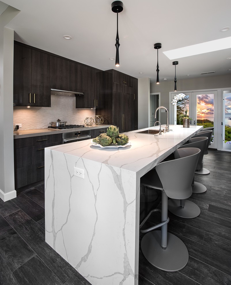Design ideas for a mid-sized contemporary galley open plan kitchen in Los Angeles with an undermount sink, flat-panel cabinets, brown cabinets, quartz benchtops, beige splashback, porcelain splashback, panelled appliances, porcelain floors, with island, brown floor and white benchtop.