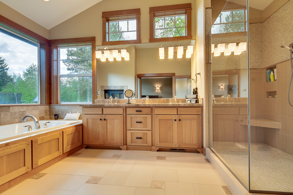 This is an example of a large traditional master bathroom in Portland with an undermount sink, shaker cabinets, medium wood cabinets, granite benchtops, a drop-in tub, a corner shower, a one-piece toilet, beige tile, mosaic tile, beige walls and travertine floors.