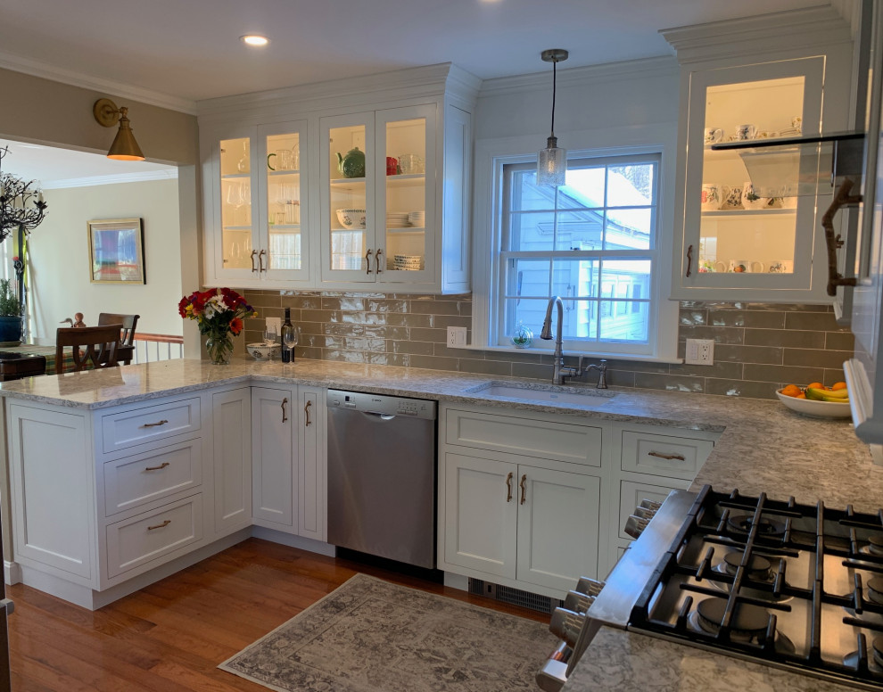 Kitchen pantry - mid-sized transitional u-shaped medium tone wood floor kitchen pantry idea in Burlington with an undermount sink, shaker cabinets, white cabinets, quartz countertops, green backsplash, subway tile backsplash, stainless steel appliances, a peninsula and beige countertops