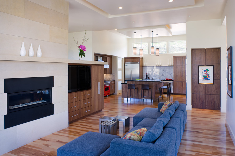 This is an example of a contemporary open concept living room in Austin with white walls, a standard fireplace and a wall-mounted tv.