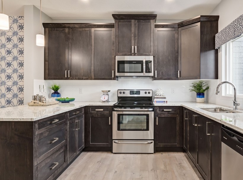 Photo of a mid-sized contemporary l-shaped eat-in kitchen in Calgary with an undermount sink, shaker cabinets, brown cabinets, granite benchtops, white splashback, ceramic splashback, stainless steel appliances, linoleum floors, with island and beige floor.