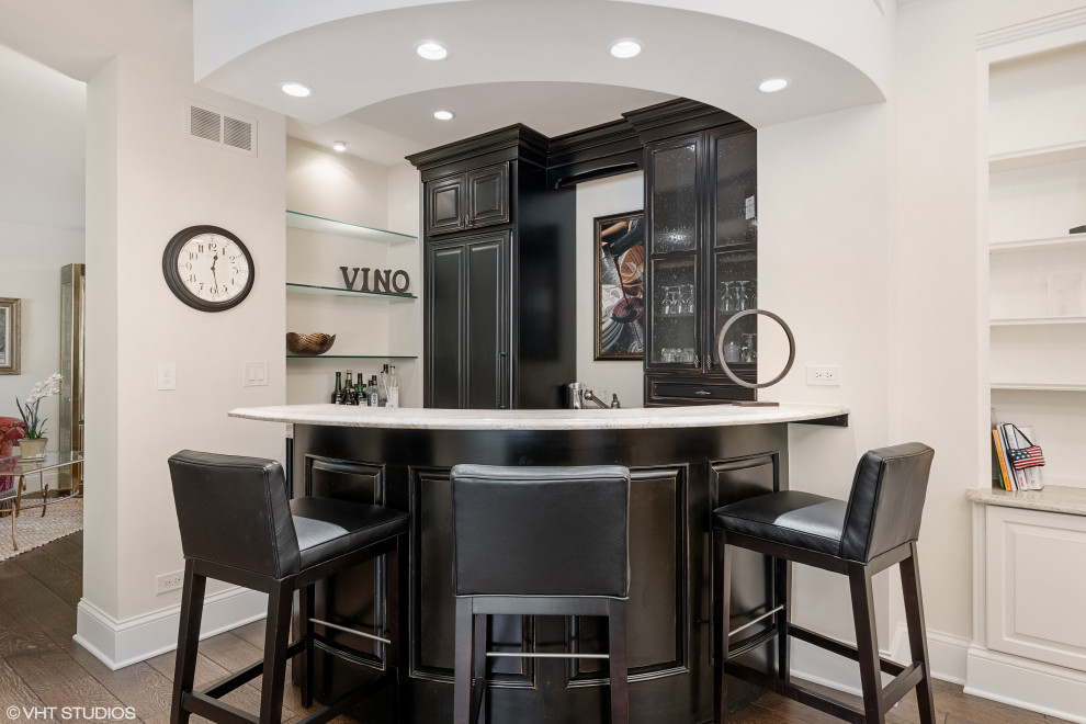 Inspiration for a mid-sized contemporary wet bar in Chicago with an undermount sink, glass-front cabinets, black cabinets, granite benchtops, white splashback, granite splashback, dark hardwood floors, brown floor and white benchtop.