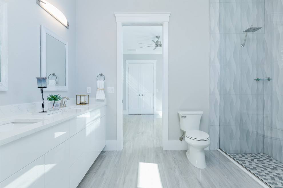 Bathroom - mid-sized mediterranean ceramic tile, gray floor, double-sink and tray ceiling bathroom idea in Other with raised-panel cabinets, white cabinets, a one-piece toilet, gray walls, an undermount sink, quartz countertops, a hinged shower door, white countertops and a built-in vanity