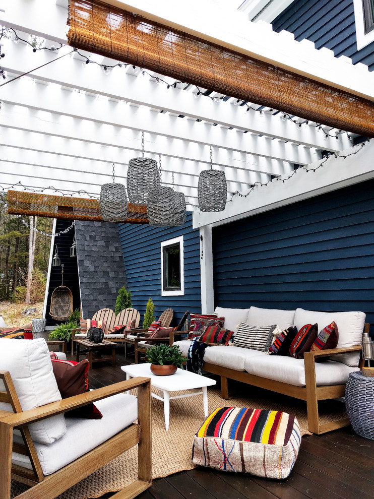 Expansive eclectic backyard deck in New York with a pergola.